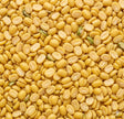 Close-up of yellow split peas with green seeds.