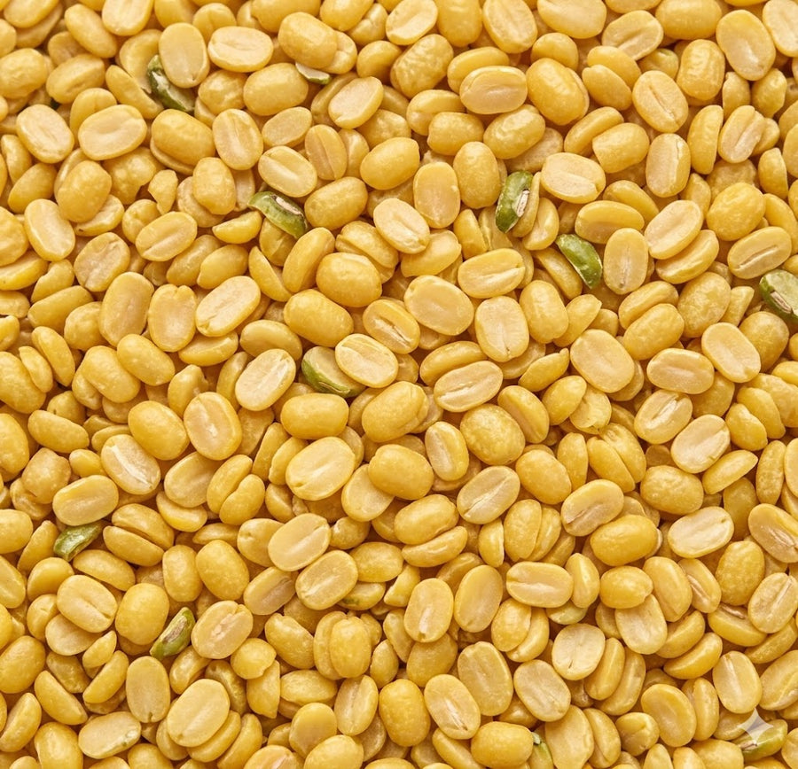Close-up of yellow split peas with green seeds.