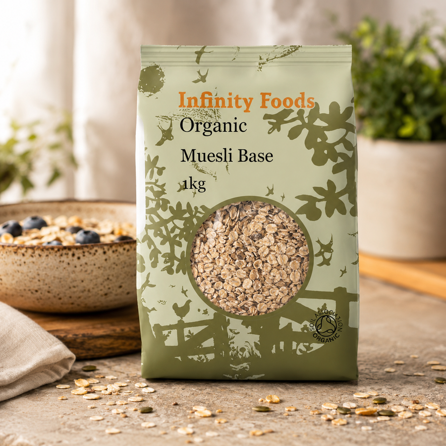 Infinity Foods Organic Muesli Base package on a wooden surface with a bowl of muesli in the background.