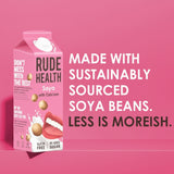 Rude Health soya product packaging on a pink background with text about sustainably sourced soya beans.