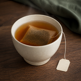 Brewed amber Hojicha tea with tea bag