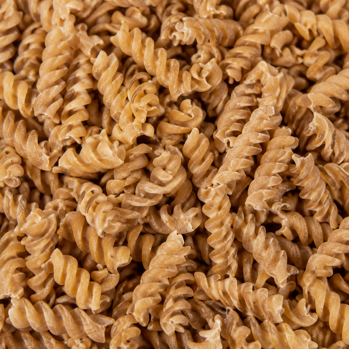 Extreme close-up of dry organic brown rice fusilli
