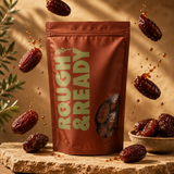 Bag of Rough & Ready dates with dates falling around it on a wooden surface.