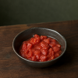 Chopped tomatoes in a small dark bowl