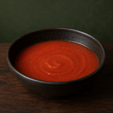 Plain blended tomato soup in a dark bowl