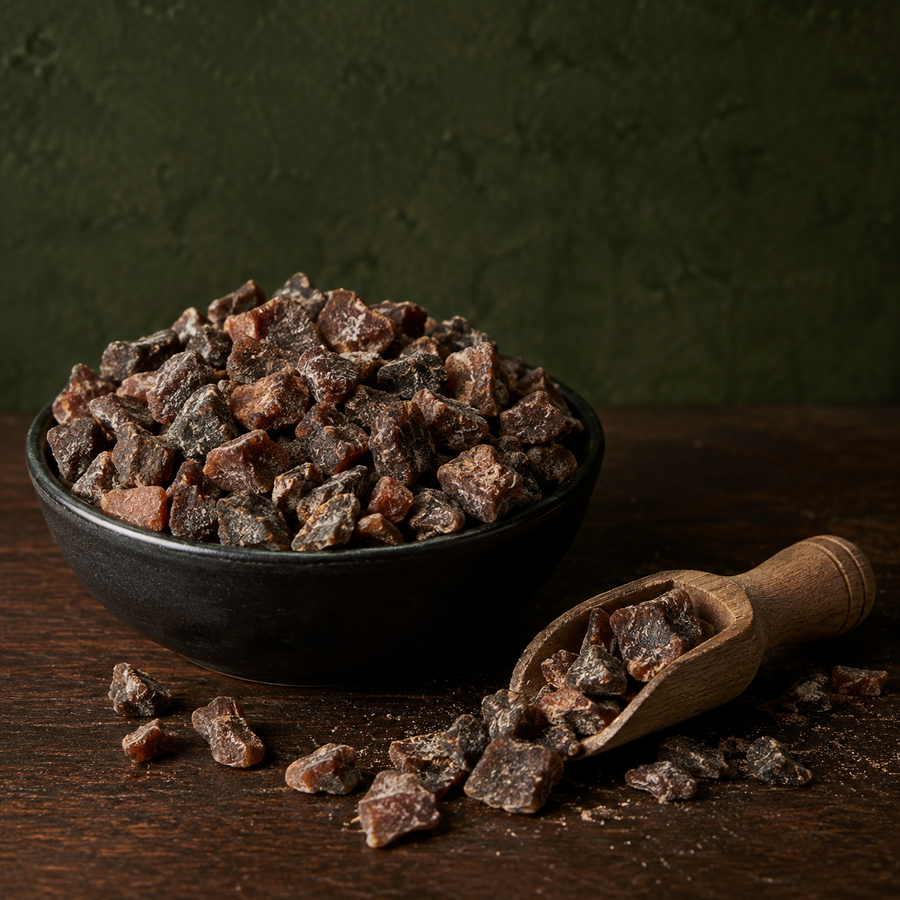 Organic chopped apricots in a black bowl with scoop