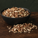 Organic pecan pieces in a black bowl