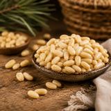 Pine nuts in a small bowl on a wooden surface with a woven basket in the background.