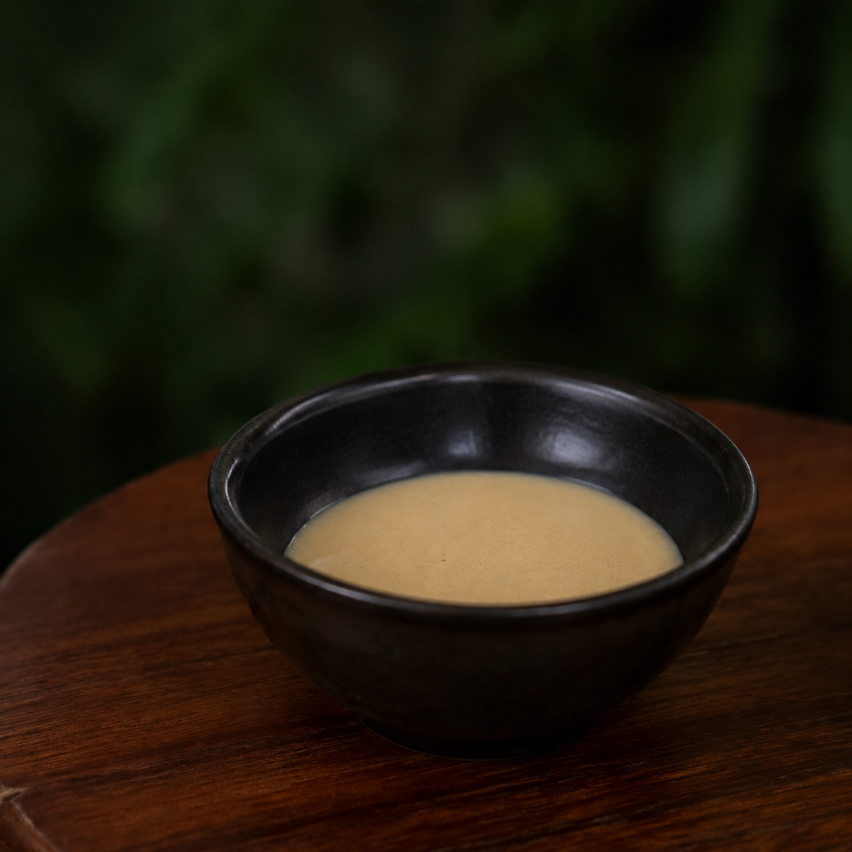 Light tahini in a small dark bowl