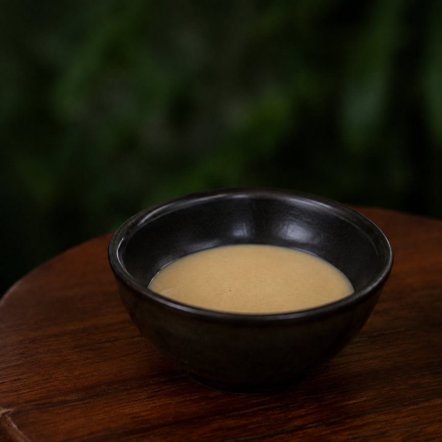 Light tahini in a small dark bowl