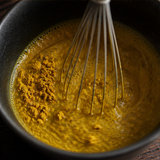 Organic turmeric latte being whisked